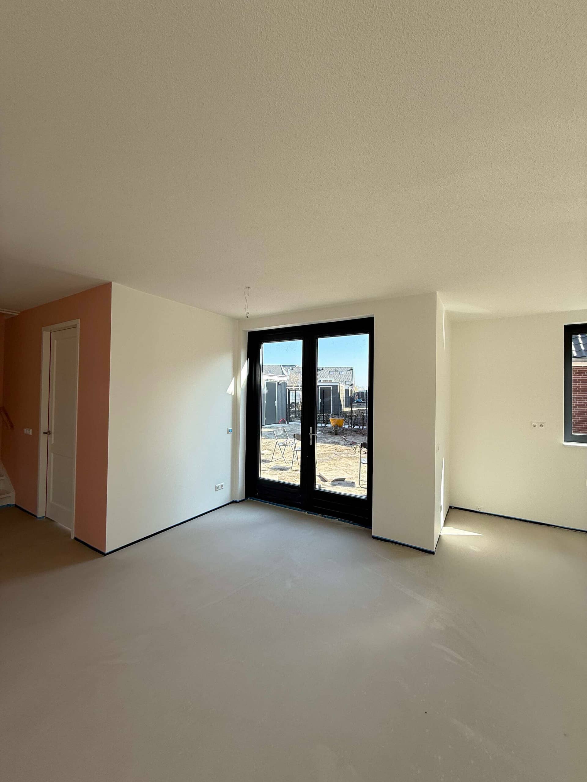 Renovlies nieuwbouw Delft: voorbeeld woonkamer met zalmroze accentmuur