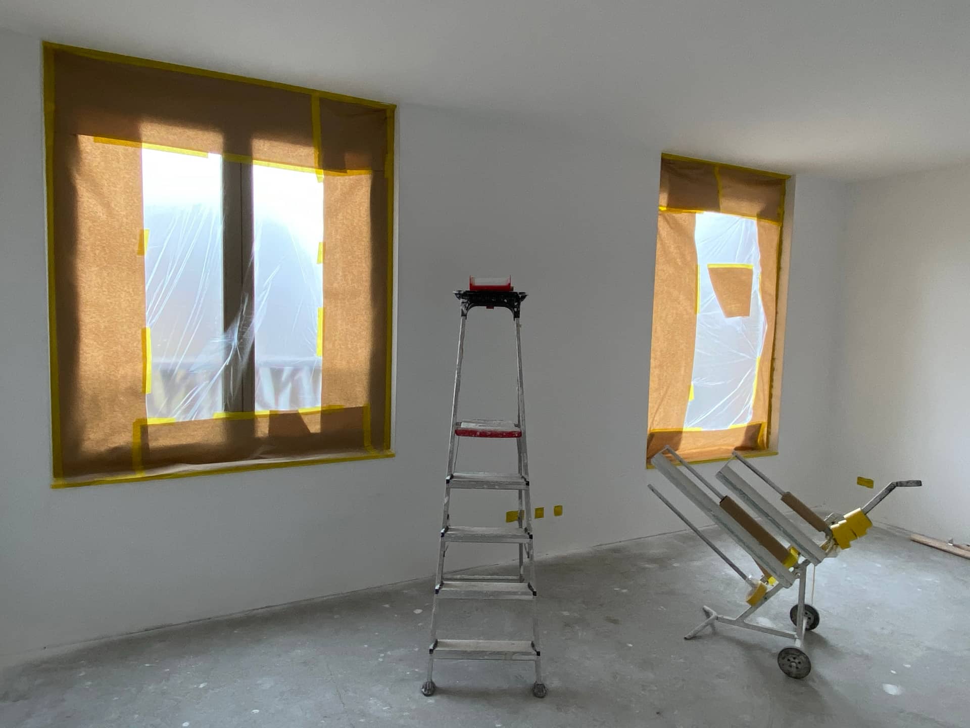 Kamer klaar voor latex spuiten met ramen afgeplakt in kraftpapier