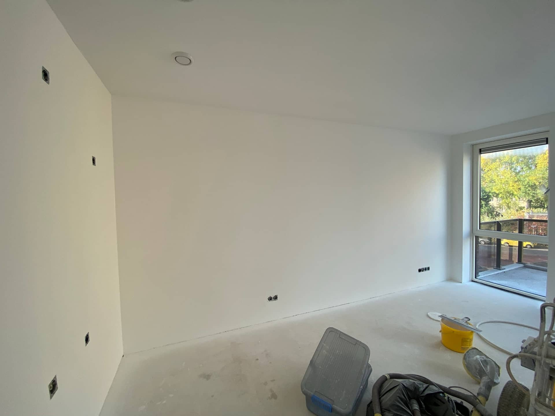 Nieuwbouwkamer tijdens latex spuiten met gereedschap