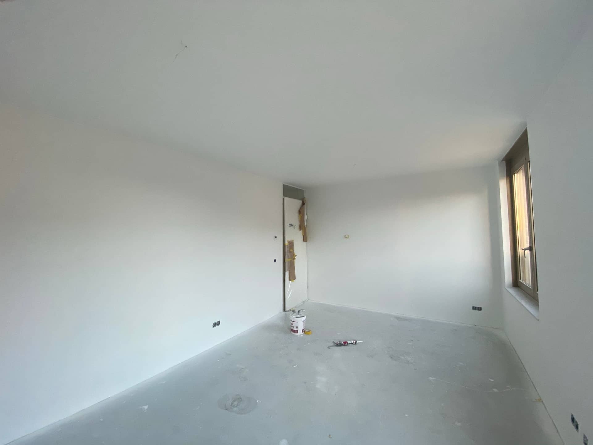 Kamer halverwege latex spuiten, doorgang afgeplakt