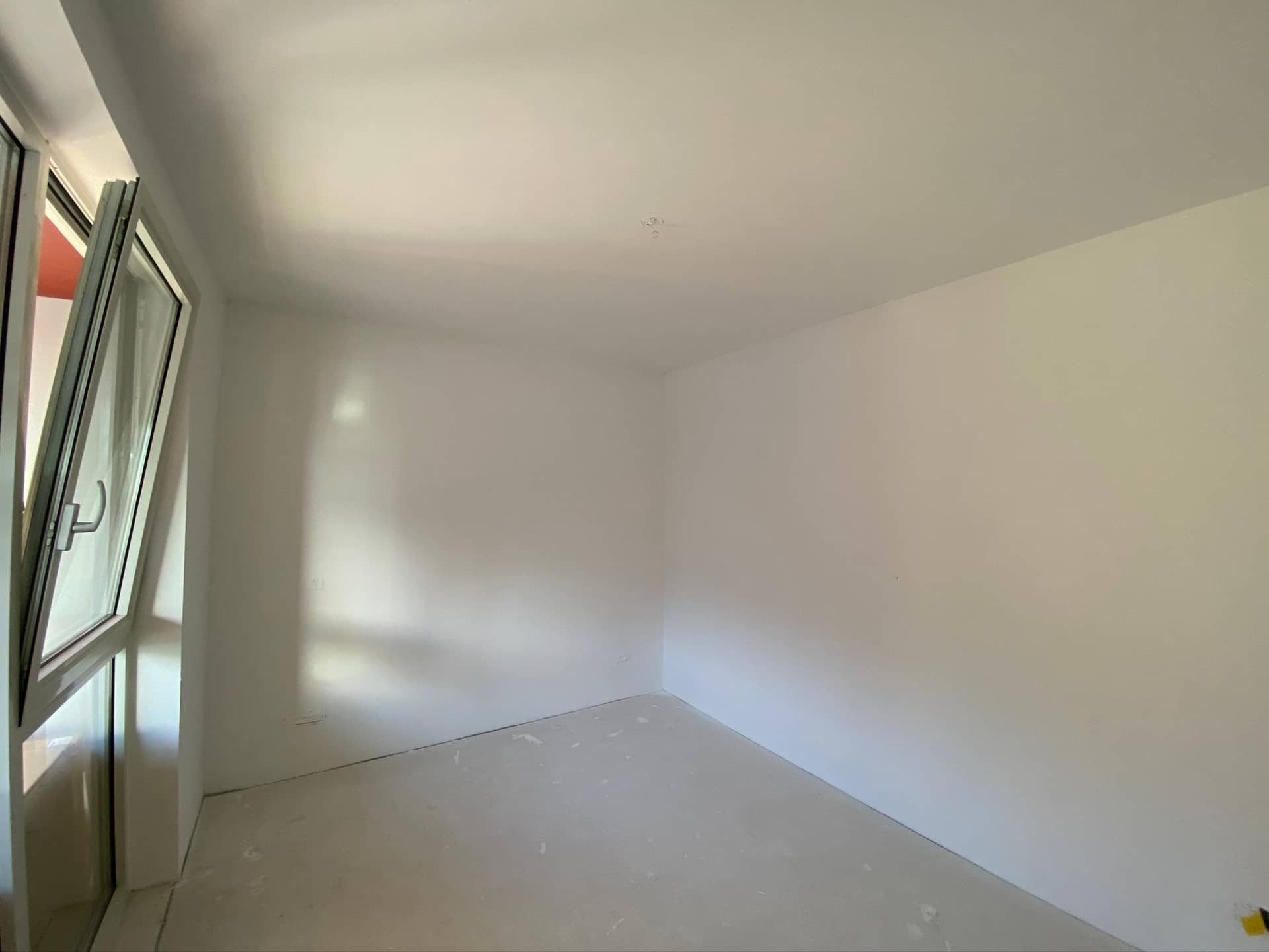Kleine slaapkamer met glazen deur en zwart kozijn