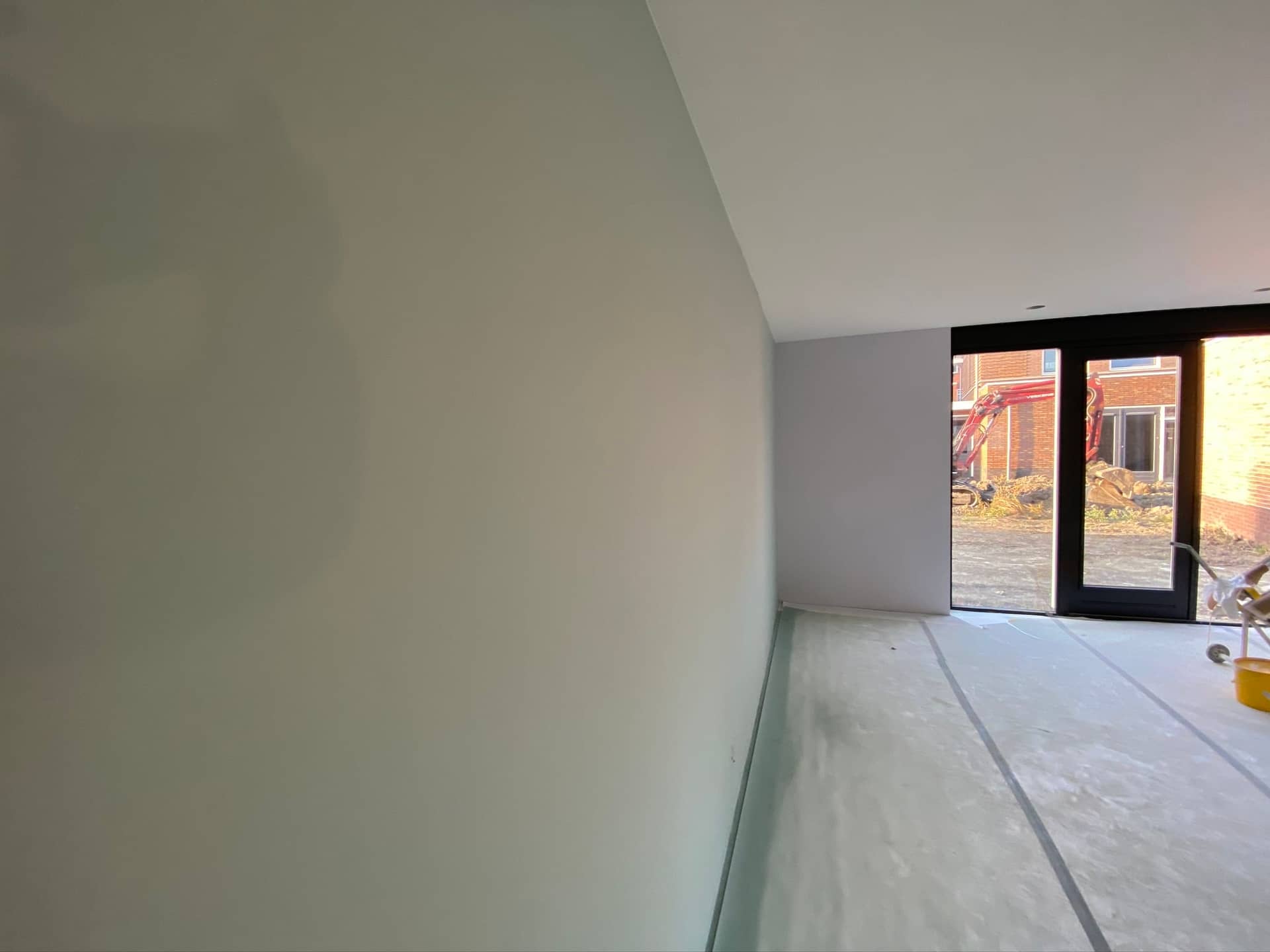 Wand in salie-groen latex, nieuwbouw in aanbouw