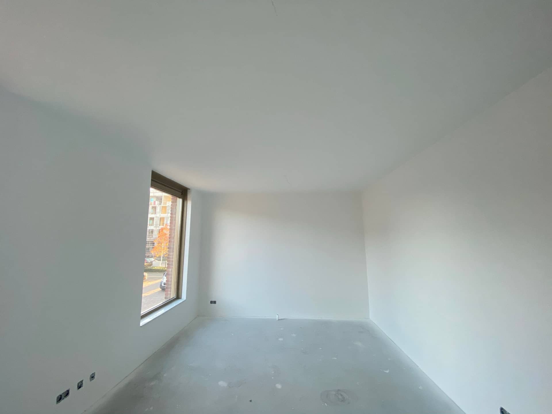 Slaapkamer met herfstuitzicht en appartementen
